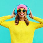 Portrait of happy smiling young woman with headphones listening