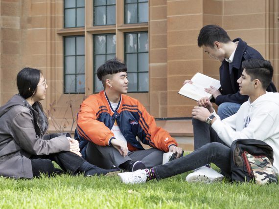 Group of international students sitting on the lawn outside Anderson Stuart Building