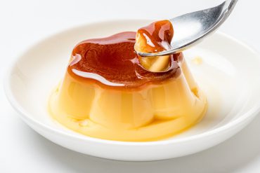 A spoon taking out a piece of pudding.