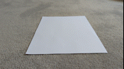 Animated GIF of name tent folding. A4 sheet of paper is folded in half once and then into quarters across, and propped into a triangular prism.