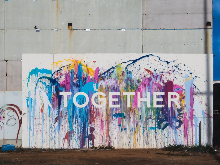 Image of the word "together" spray painted onto a wall