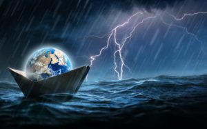 World in a paper boat floating in the ocean in a middle of a storm. Faith despite world crisis and hardship conceptual theme.