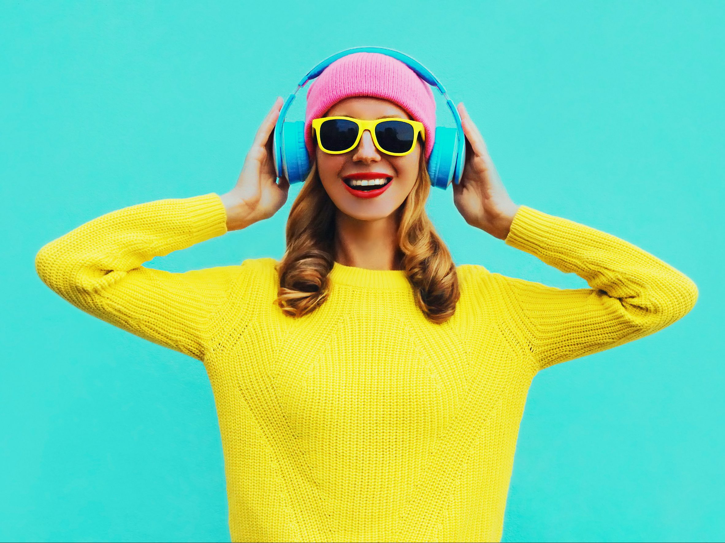Portrait of happy smiling young woman with headphones listening