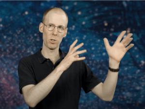An academic standing in front of a starry background, explaining artificial intelligence