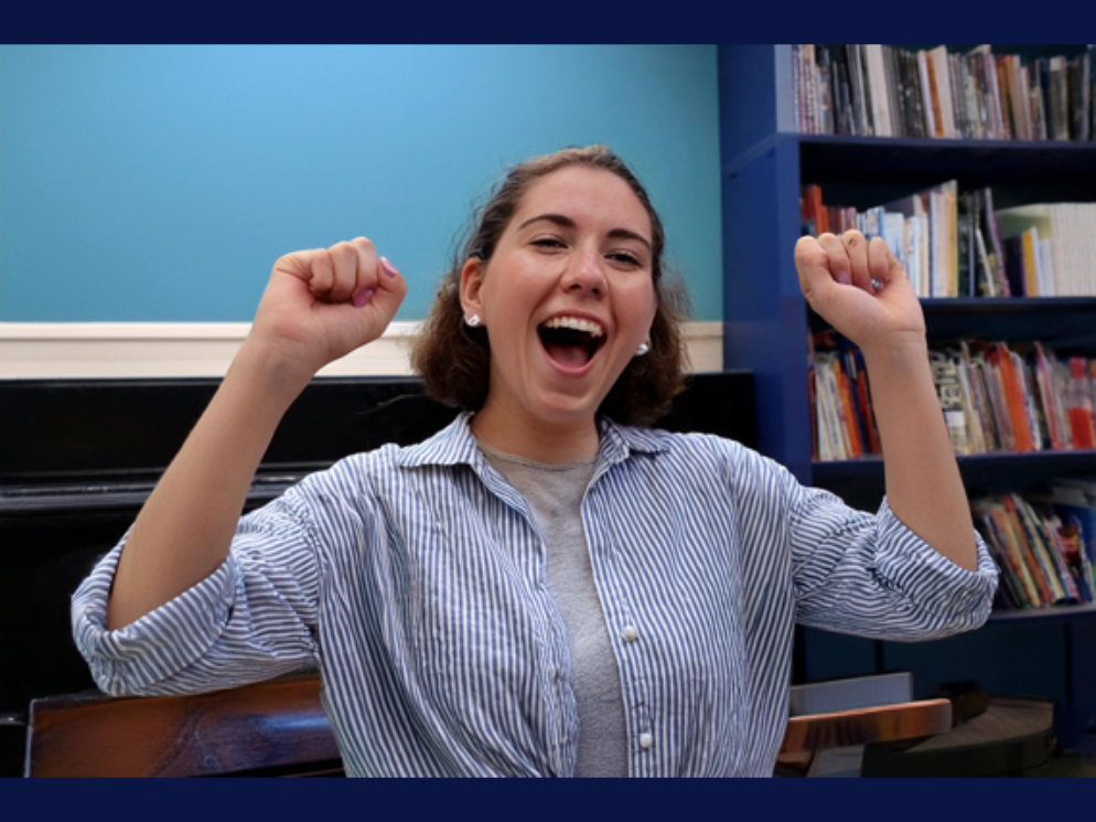 Student singing happily with raised fists.