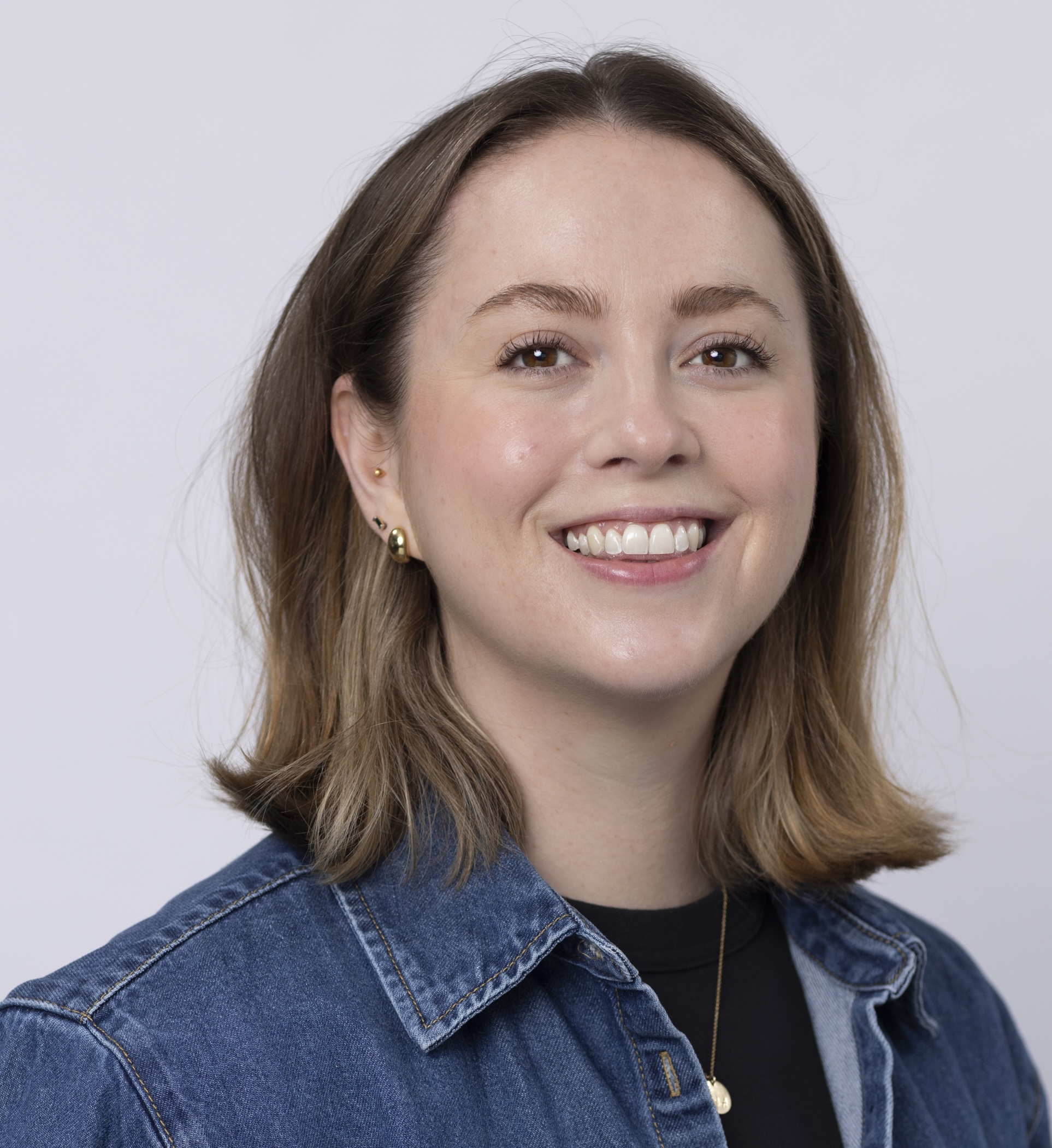 Alix has mid-length dark blonde hair and is smiling at the camera.