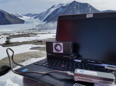 A laptop computer connected to an Oxford Nanopore MinION sequencing device, in Antarctica